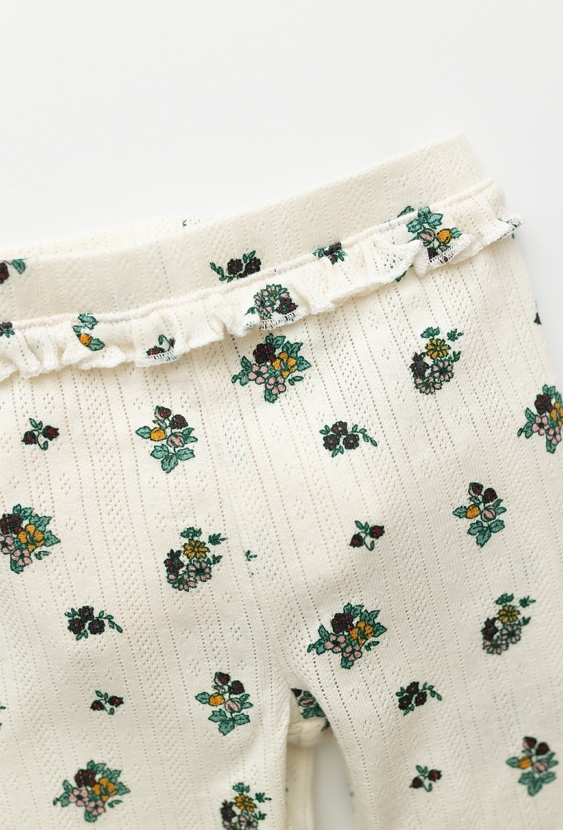 Białe legginsy niemowlęce w kwiatuszki z materiału pointelle