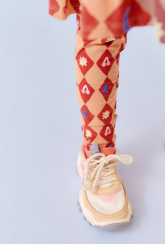 Pomarańczowe legginsy dziewczęce z motywem cyrkowym.