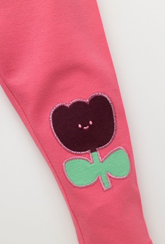 Różowe legginsy niemowlęce z naszywkami kwiatków na kolankach