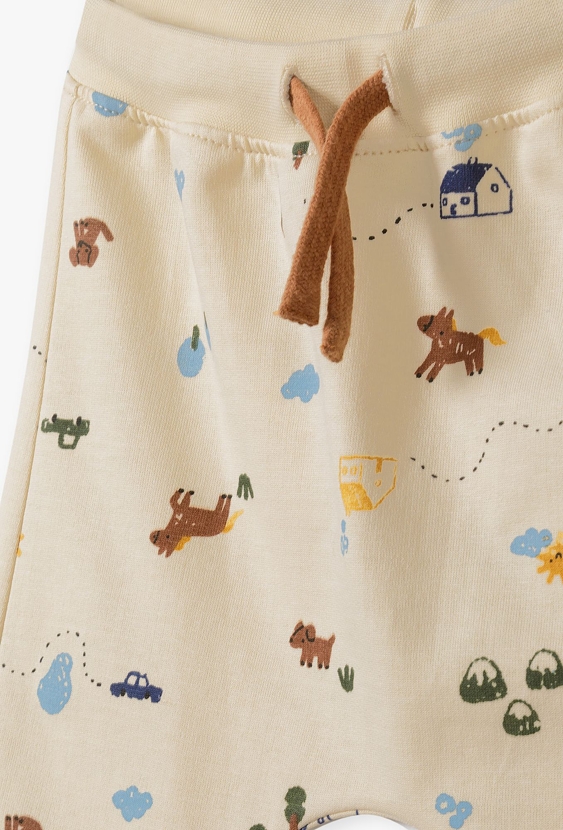 Beżowe bawełniane spodnie dresowe niemowlęce z nadrukiem