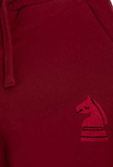 Czerwone spodnie dresowe dziecięce z haftem szachowym.