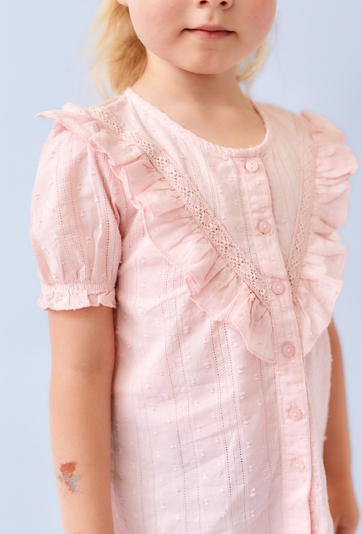 Różowa koszula dziewczęca z krótkim rękawem i falbanką.