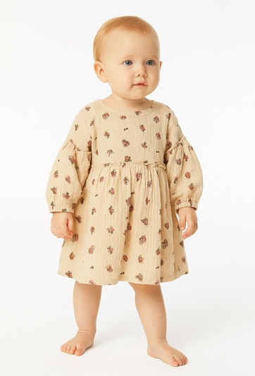 Beżowa sukienka dziewczęca z kwiatowym nadrukiem.
