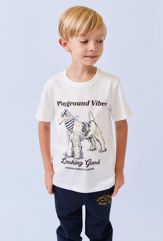 Biała koszulka chłopięca z nadrukiem pieska i napisem.
