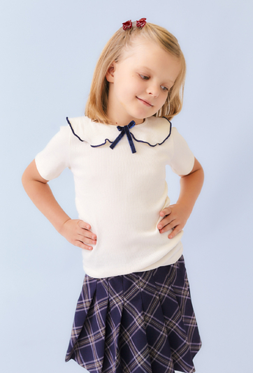 Dziewczęca koszulka ecru z ozdobnym kołnierzykiem i kokardką.
