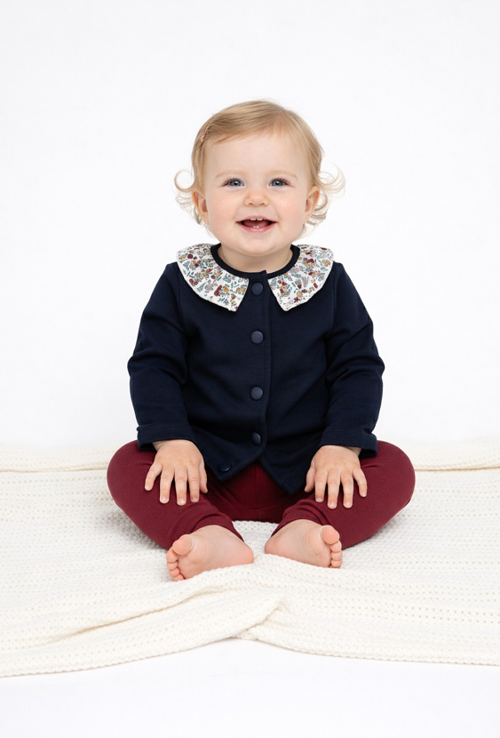 Granatowa bluza niemowlęca z kwiatowym kołnierzykiem.