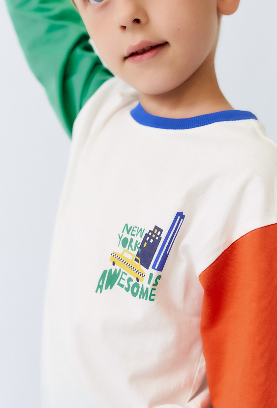 Bluzka dziecięca ecru z kolorowymi rękawami.