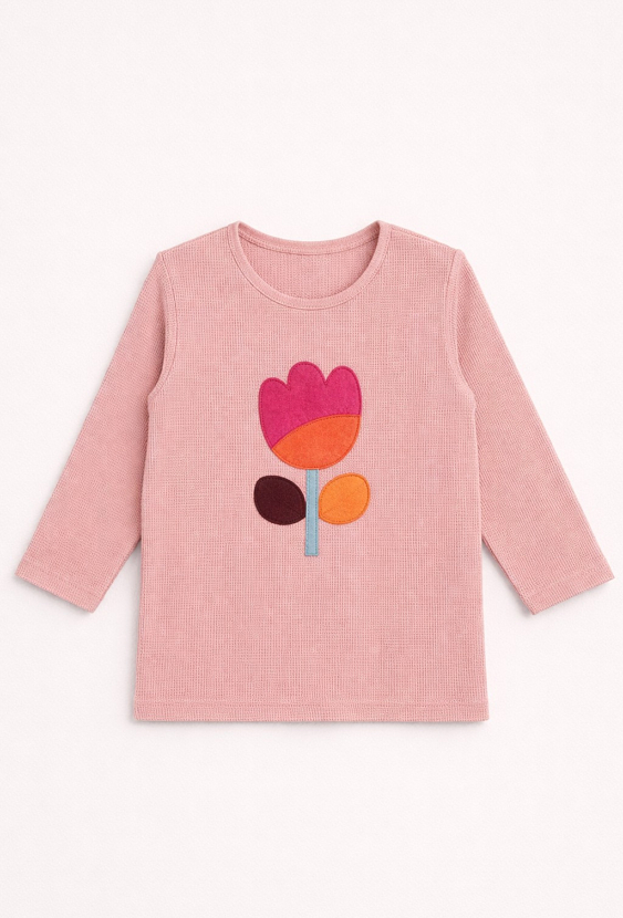 Różowa bluzka dziewczęca z długim rękawem i naszywką.