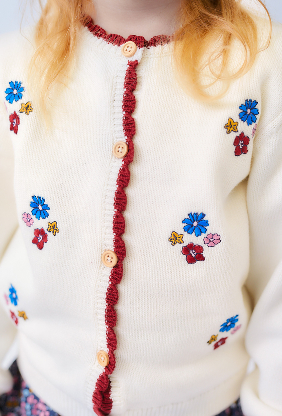 Dziewczęcy sweter ecru z kwiatowymi haftami.