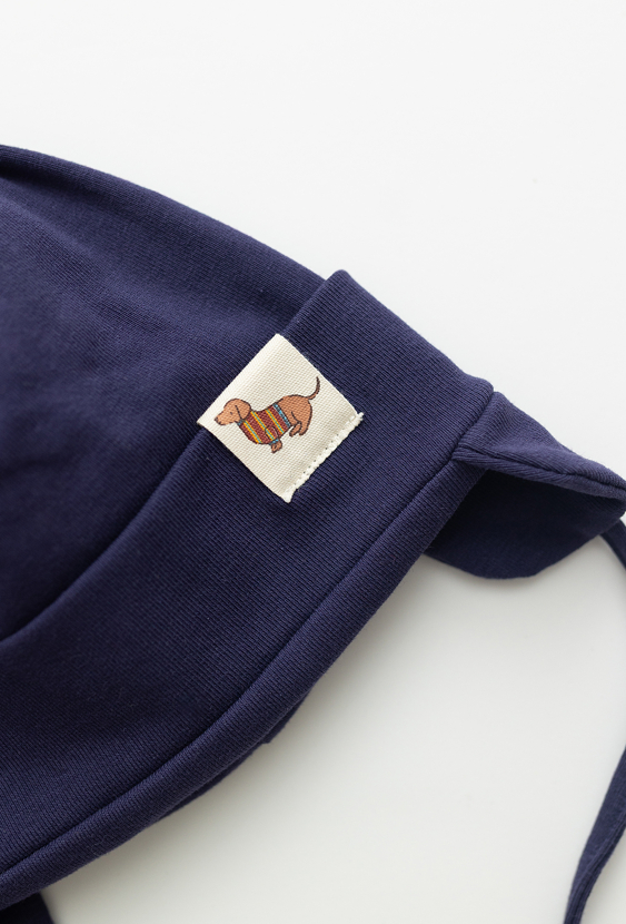 Granatowa czapka niemowlęca z wiązaniem i naszywką.