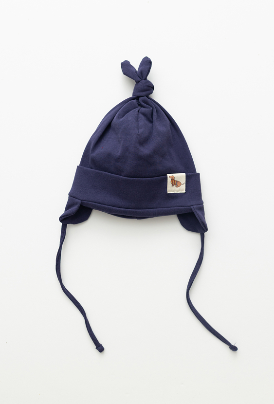 Granatowa czapka niemowlęca z wiązaniem i naszywką.