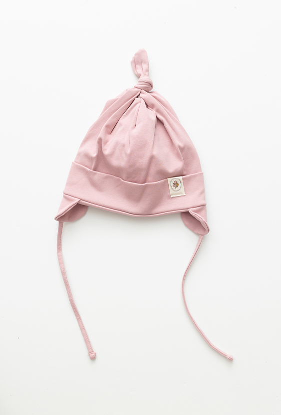 Różowa czapka niemowlęca z wiązaniem i naszywką.