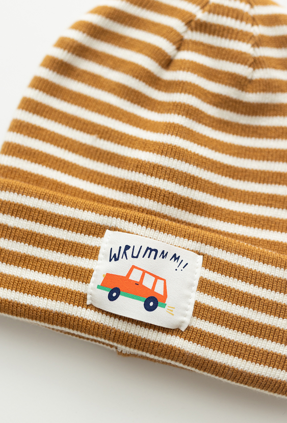 Beżowa cienka czapka dziecięca w paski z naszywką.